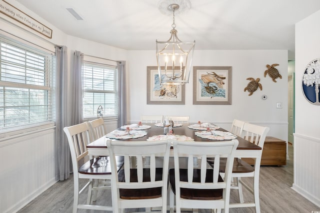 919 Dock Pl, Murrells Inlet, SC 29576 - dining space with light wood-style flooring, a chandelier, and wainscoting