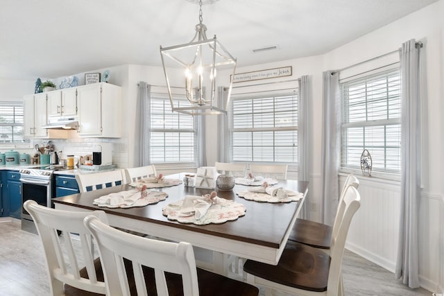 919 Dock Pl, Murrells Inlet, SC 29576 - dining room featuring a chandelier, light wood finished floors, and wainscoting
