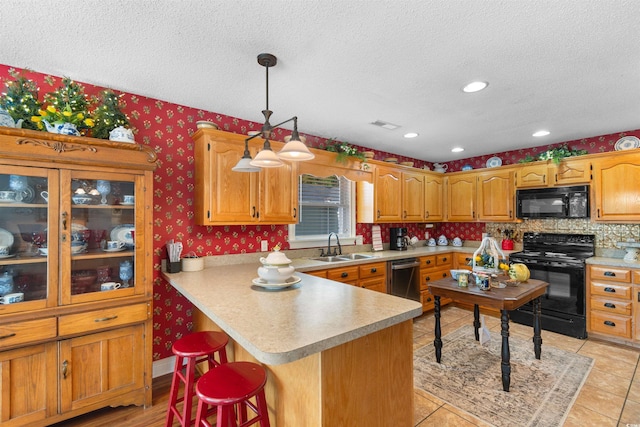 460 River Front St S, Conway, SC 29527 - kitchen featuring black appliances, a textured ceiling, wallpapered walls, a kitchen breakfast bar, and light countertops