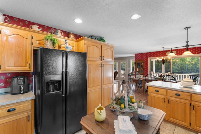 460 River Front St S, Conway, SC 29527 - kitchen with black fridge with ice dispenser, a textured ceiling, light countertops, wallpapered walls, and hanging light fixtures