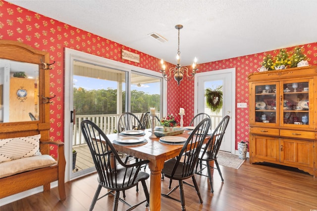 460 River Front St S, Conway, SC 29527 - dining space featuring wallpapered walls, a chandelier, healthy amount of natural light, wood finished floors, and a textured ceiling
