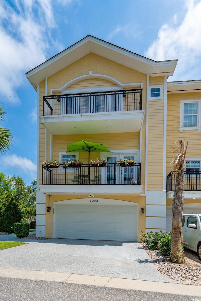 4302 Grande Harbour Blvd Unit 4302, Little River, SC 29566 - view of front of house with a balcony, a garage, concrete driveway, and stucco siding