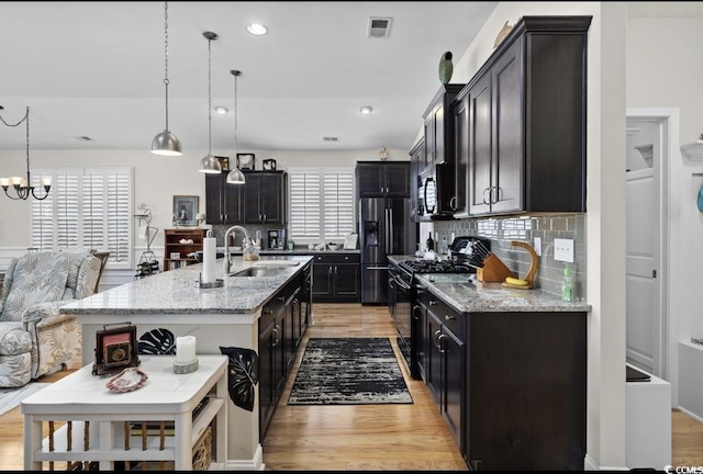 216 Coral Beach Cir, Myrtle Beach, SC 29575 - kitchen featuring black appliances, light wood finished floors, backsplash, light stone counters, and recessed lighting