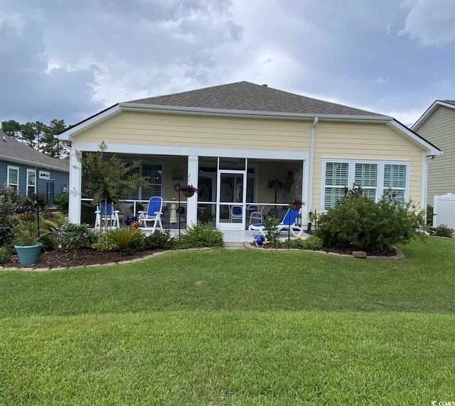 216 Coral Beach Cir, Myrtle Beach, SC 29575 - rear view of house featuring a lawn, a sunroom, and a shingled roof