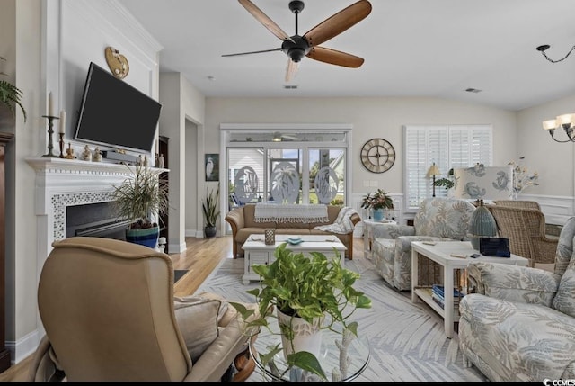 216 Coral Beach Cir, Myrtle Beach, SC 29575 - living room with ceiling fan, a tile fireplace, a chandelier, light wood finished floors, and vaulted ceiling