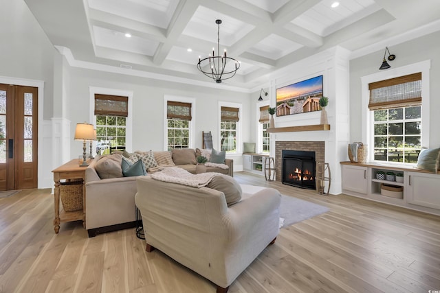 1320 James Island Ave, North Myrtle Beach, SC 29582 - living area with beamed ceiling, light wood-style floors, a warm lit fireplace, a chandelier, and plenty of natural light