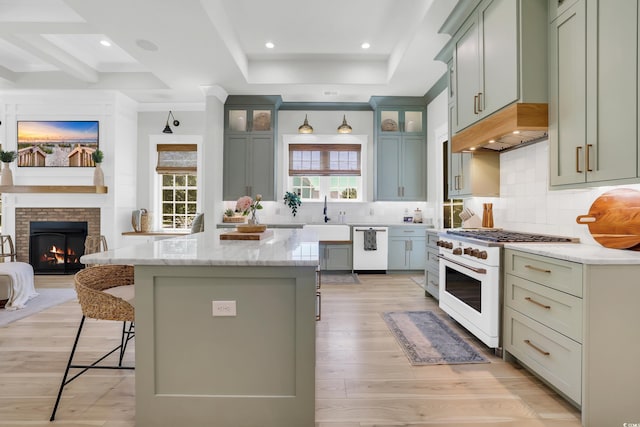 1320 James Island Ave, North Myrtle Beach, SC 29582 - kitchen with white appliances, a kitchen bar, a fireplace, light stone countertops, and a kitchen island