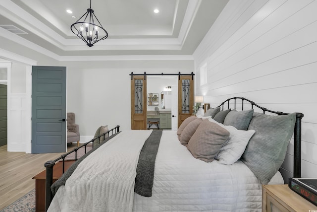 1320 James Island Ave, North Myrtle Beach, SC 29582 - bedroom featuring wood finished floors, a chandelier, a tray ceiling, recessed lighting, and a barn door