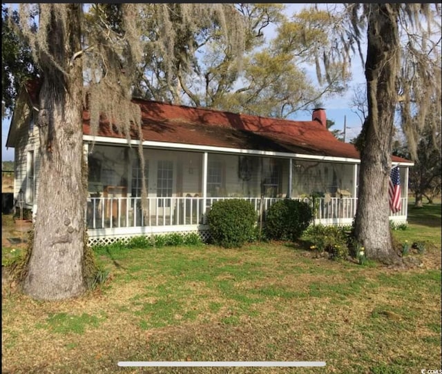 673 Brick Chimney Rd, Georgetown, SC 29440 - back of property with a sunroom, a yard, and a chimney