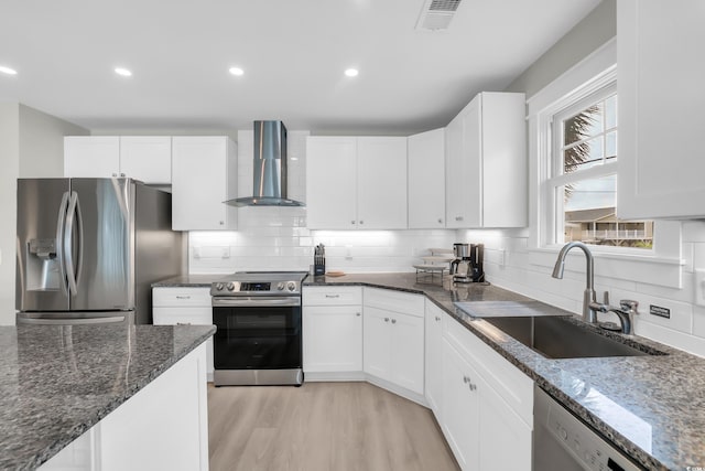330 51st Ave N, North Myrtle Beach, SC 29582 - kitchen featuring stainless steel appliances, wall chimney range hood, white cabinets, light wood finished floors, and recessed lighting