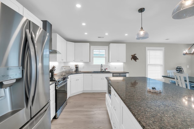 330 51st Ave N, North Myrtle Beach, SC 29582 - kitchen featuring appliances with stainless steel finishes, recessed lighting, light wood finished floors, wall chimney range hood, and white cabinets