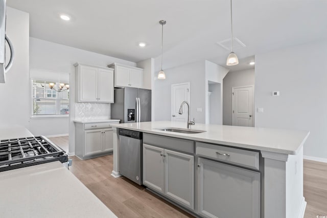 9051 Fort Hill Way, Myrtle Beach, SC 29579 - kitchen with stainless steel appliances, light wood-style floors, light countertops, pendant lighting, and a kitchen island with sink