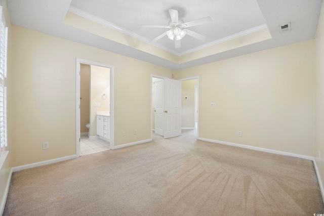 3484 Trailside Dr, Little River, SC 29566 - unfurnished bedroom with a tray ceiling, ornamental molding, light carpet, and connected bathroom