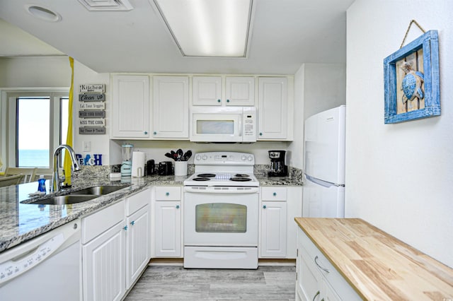 2711 S Ocean Blvd Unit 1522, North Myrtle Beach, SC 29582 - kitchen featuring white appliances, white cabinets, light wood-style floors, and light stone countertops