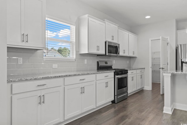 225 Astoria Park Loop, Conway, SC 29526 - kitchen with appliances with stainless steel finishes, white cabinets, dark wood-type flooring, decorative backsplash, and light stone countertops