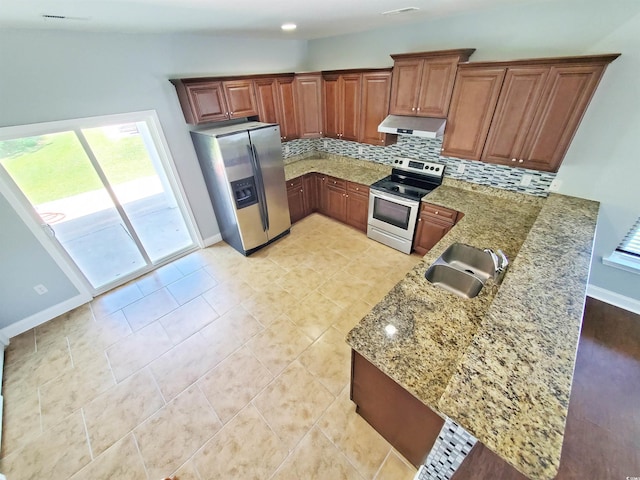 1017 Dinger Dr Unit 1017, Myrtle Beach, SC 29588 - kitchen with appliances with stainless steel finishes, under cabinet range hood, decorative backsplash, light stone counters, and brown cabinets