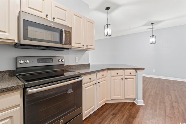 105 Ashley Park Dr Unit 2B, Myrtle Beach, SC 29579 - kitchen featuring appliances with stainless steel finishes, dark countertops, a peninsula, dark wood-style floors, and hanging light fixtures
