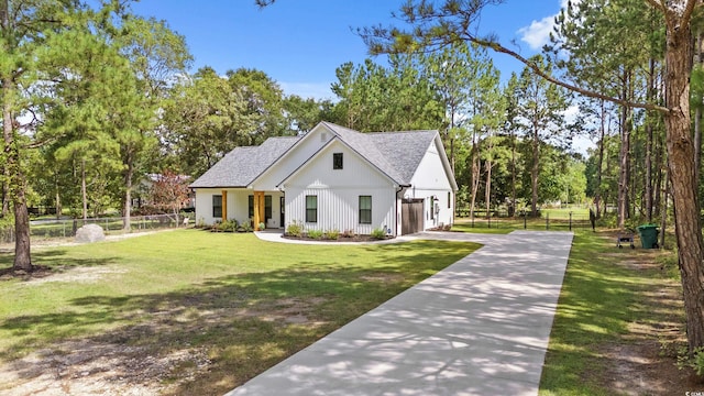 7405 Louisville Rd, Aynor, SC 29511 - modern farmhouse featuring concrete driveway, a garage, a shingled roof, and view of scattered trees