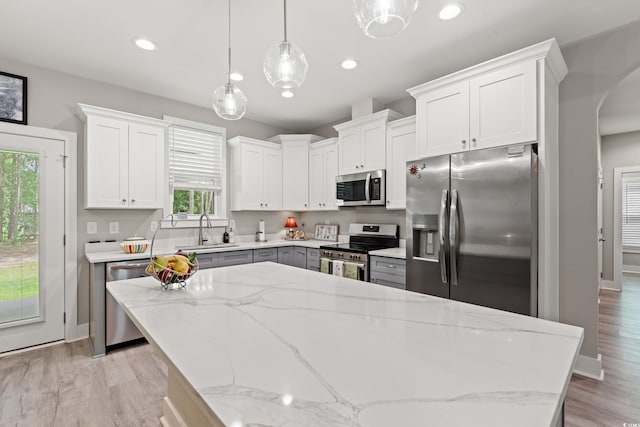 7405 Louisville Rd, Aynor, SC 29511 - kitchen featuring stainless steel appliances, arched walkways, white cabinetry, pendant lighting, and light wood-style flooring