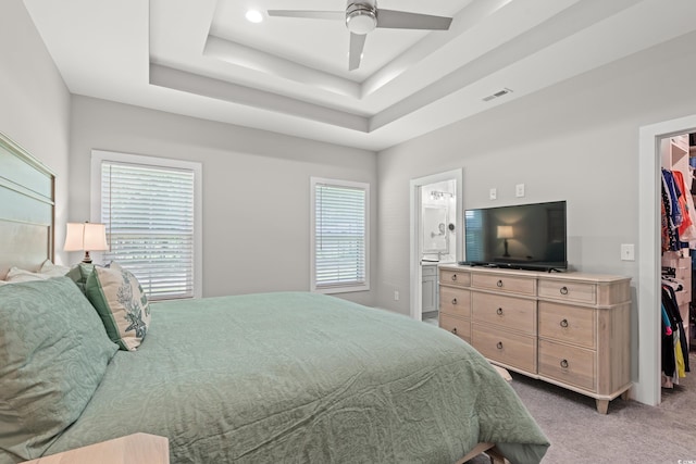 7405 Louisville Rd, Aynor, SC 29511 - bedroom featuring a walk in closet, light colored carpet, a tray ceiling, ensuite bath, and ceiling fan