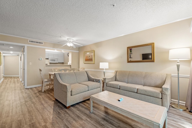 415 Ocean Creek Dr Unit 2243, Myrtle Beach, SC 29572 - living area featuring wood finished floors, a textured ceiling, a ceiling fan, and ornamental molding
