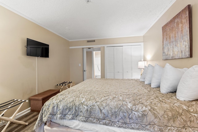 415 Ocean Creek Dr Unit 2243, Myrtle Beach, SC 29572 - bedroom with crown molding, a textured ceiling, a closet, and wood finished floors
