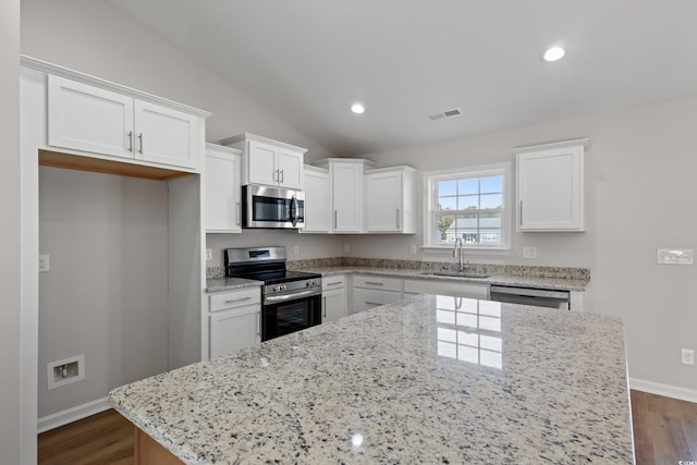 133 Cooper Ln, Georgetown, SC 29440 - kitchen with stainless steel appliances, white cabinetry, dark wood-style flooring, lofted ceiling, and recessed lighting
