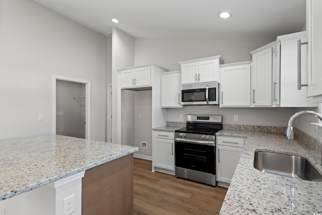 133 Cooper Ln, Georgetown, SC 29440 - kitchen featuring stainless steel appliances, vaulted ceiling, white cabinetry, dark wood-type flooring, and light stone counters