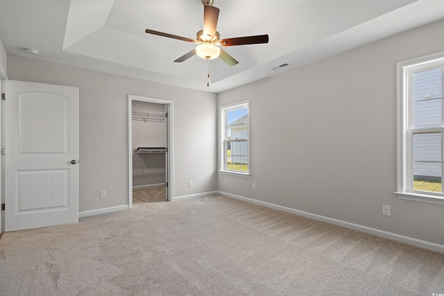 133 Cooper Ln, Georgetown, SC 29440 - unfurnished bedroom with a raised ceiling, carpet, a walk in closet, and a ceiling fan
