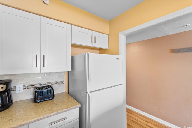 3217 S Ocean Blvd Unit 305, North Myrtle Beach, SC 29582 - kitchen with freestanding refrigerator, backsplash, white cabinets, and light wood-type flooring