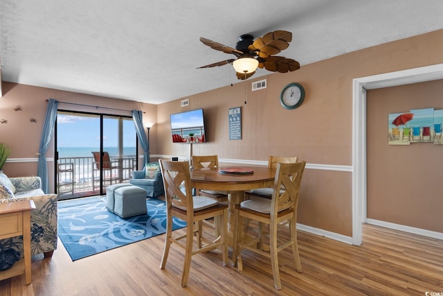 3217 S Ocean Blvd Unit 305, North Myrtle Beach, SC 29582 - dining space with wood finished floors, a ceiling fan, and a textured ceiling