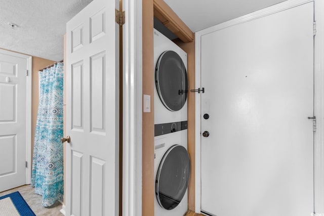 3217 S Ocean Blvd Unit 305, North Myrtle Beach, SC 29582 - laundry area featuring stacked washer / dryer and a textured ceiling
