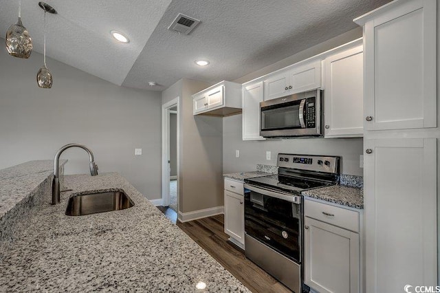 5087 Marigold Rd, Conway, SC 29527 - kitchen featuring appliances with stainless steel finishes, dark wood-style floors, white cabinets, a textured ceiling, and light stone countertops