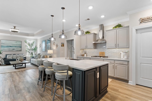 3382 Eversheen Dr, Little River, SC 29566 - kitchen featuring wall chimney range hood, open floor plan, light countertops, ornamental molding, and a kitchen bar
