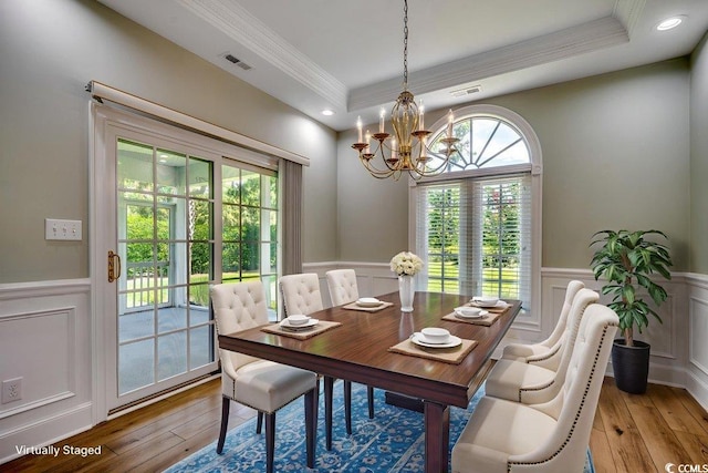 3535 Golf Ave, Little River, SC 29566 - dining space with a chandelier, ornamental molding, wainscoting, a decorative wall, and light wood-type flooring