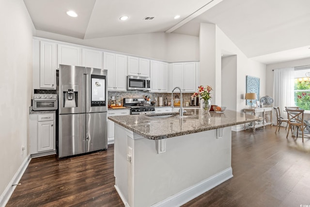 756 Culbertson Ave, Myrtle Beach, SC 29577 - kitchen featuring appliances with stainless steel finishes, lofted ceiling, a kitchen breakfast bar, decorative backsplash, and dark wood-type flooring