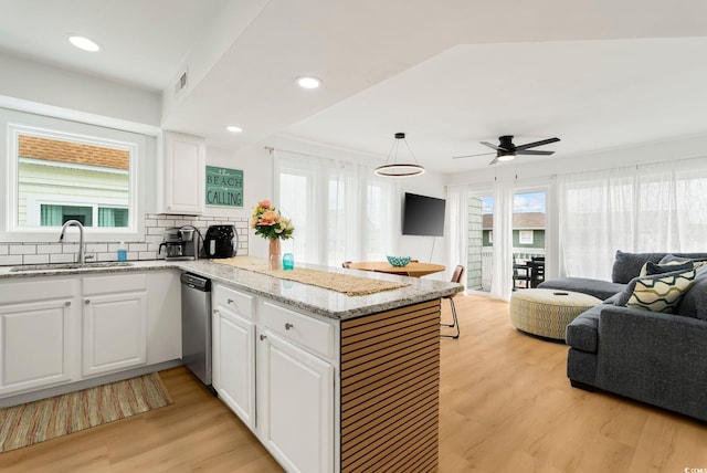 5700 Nixon St, North Myrtle Beach, SC 29582 - kitchen featuring open floor plan, dishwasher, a peninsula, white cabinetry, and light wood-style flooring