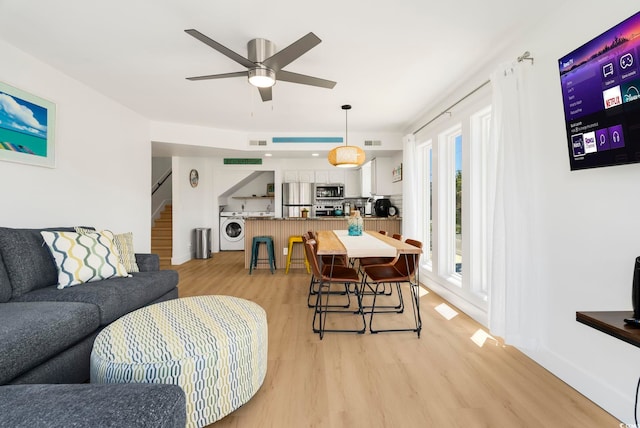 5700 Nixon St, North Myrtle Beach, SC 29582 - living area featuring washer / clothes dryer, light wood-style floors, stairs, and a ceiling fan