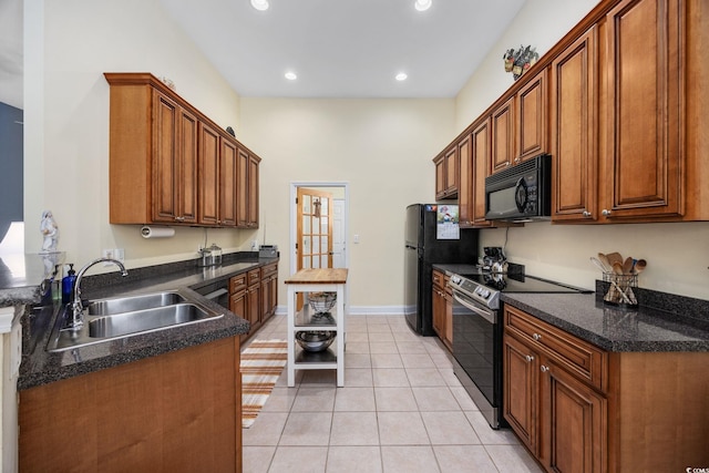 371 Sea Turtle Dr, Myrtle Beach, SC 29588 - kitchen with black microwave, stainless steel range with electric cooktop, freestanding refrigerator, light tile patterned floors, and brown cabinetry