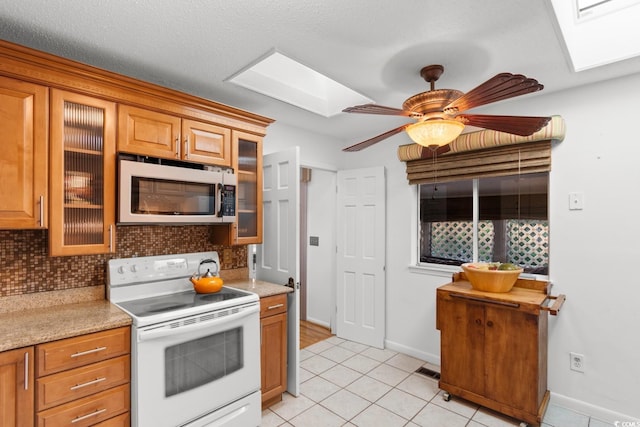 503 Plantation Dr, Surfside Beach, SC 29575 - kitchen with a skylight, electric range, light tile patterned flooring, and tasteful backsplash