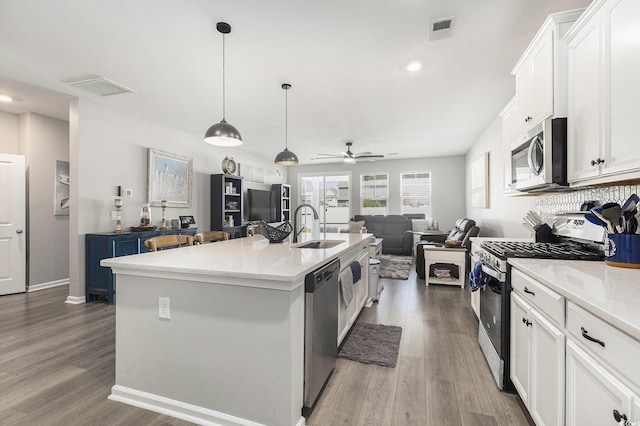 312 Cattle Drive Cir, Myrtle Beach, SC 29588 - kitchen featuring appliances with stainless steel finishes, open floor plan, white cabinetry, wood finished floors, and recessed lighting