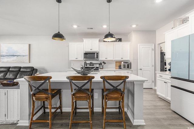 312 Cattle Drive Cir, Myrtle Beach, SC 29588 - kitchen featuring stainless steel microwave, freestanding refrigerator, light countertops, backsplash, and recessed lighting