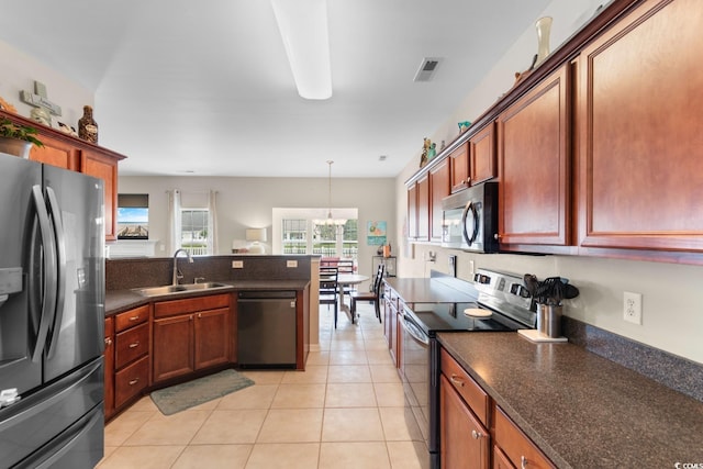 569 Ramblewood Cir, Little River, SC 29566 - kitchen featuring appliances with stainless steel finishes, dark countertops, a peninsula, light tile patterned flooring, and pendant lighting