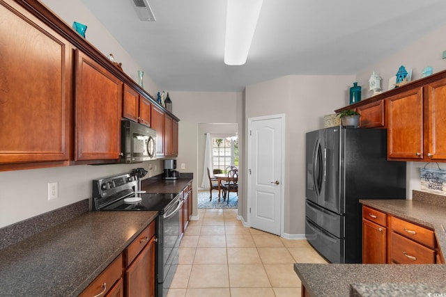 569 Ramblewood Cir, Little River, SC 29566 - kitchen featuring range with electric stovetop, dark countertops, freestanding refrigerator, and light tile patterned floors
