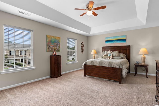 569 Ramblewood Cir, Little River, SC 29566 - bedroom featuring a tray ceiling, light carpet, and a ceiling fan