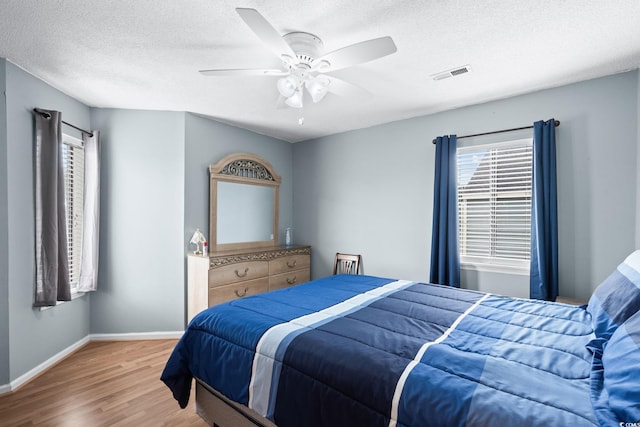 1101 Possum Trot Rd Unit A301, North Myrtle Beach, SC 29582 - bedroom featuring wood finished floors, multiple windows, a textured ceiling, and a ceiling fan