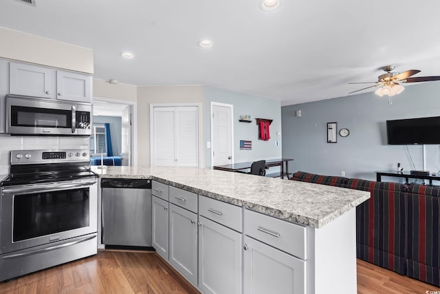 1101 Possum Trot Rd Unit A301, North Myrtle Beach, SC 29582 - kitchen with stainless steel appliances, a peninsula, light countertops, a ceiling fan, and light wood-style floors
