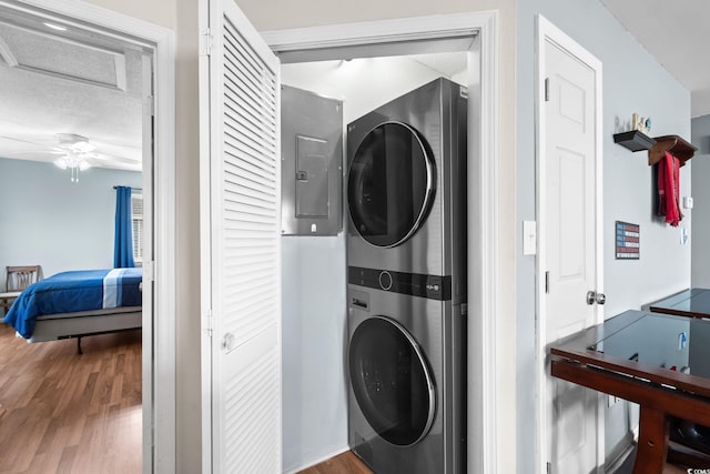 1101 Possum Trot Rd Unit A301, North Myrtle Beach, SC 29582 - laundry room with stacked washer / drying machine, wood finished floors, electric panel, attic access, and a textured ceiling