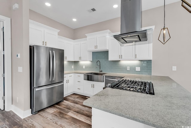202 Clam Digger Loop, Pawleys Island, SC 29585 - kitchen featuring freestanding refrigerator, island exhaust hood, dark wood-style floors, backsplash, and light stone counters