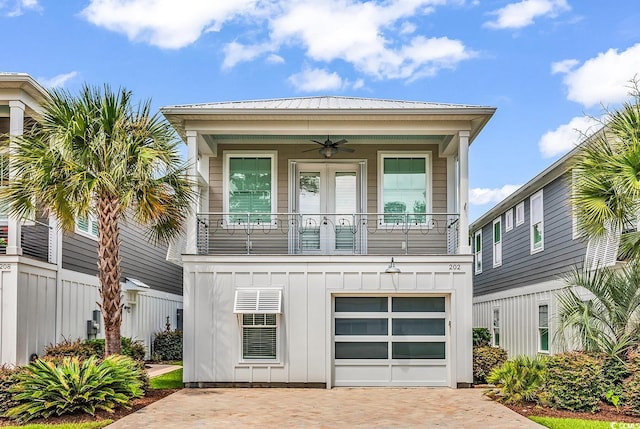 202 Clam Digger Loop, Pawleys Island, SC 29585 - view of front of house with a ceiling fan, a balcony, decorative driveway, board and batten siding, and an attached garage